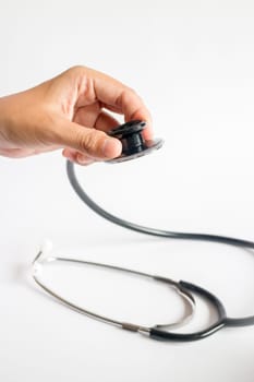 Hand on stethoscope on white background, stock photo