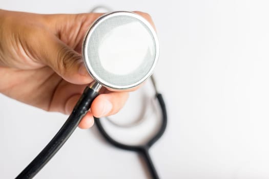 Hand on stethoscope on white background, stock photo