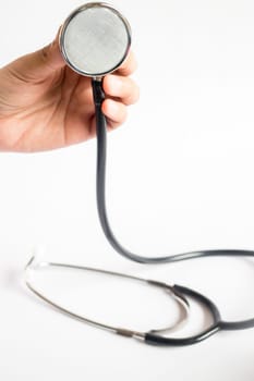 Hand on stethoscope on white background, stock photo