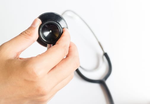 Hand on stethoscope on white background, stock photo