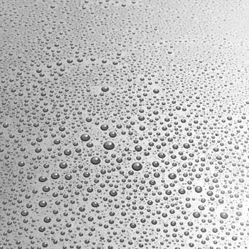 Gray surface covered with randomly sized water droplets as full frame background about staying cool or condensation concept
