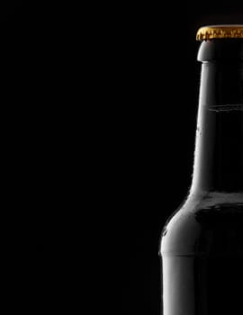 Partial cold sealed full beer bottle with condensation as a side border over a black background with copy space for your Oktoberfest advertising