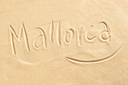Mallorca handwritten in golden beach sand conceptual of seaside tropical summer destinations around the Mediterranean, travel and tourism