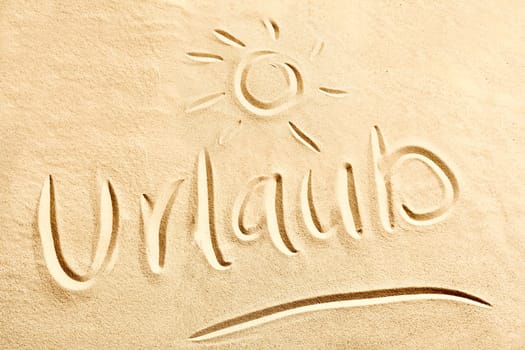 Urlaub German text with shining sun sketched on golden beach sand conceptual of coastal and tropical summer vacations at the seaside