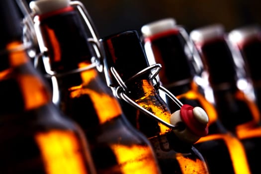 Row of beer bottles with stoppers glowing in the dark with selective focus to the stopper of an open bottle