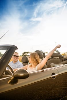 Couple in convertible looks at each other in love