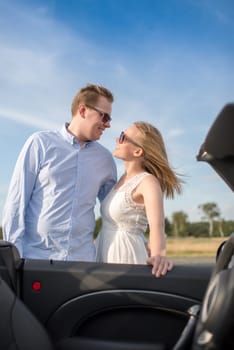 Lovers stand at the convertible and look in love in the eyes