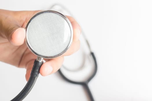Hand on stethoscope on white background, stock photo