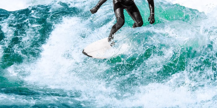 Surfing on turquoise ocean wave with close-up water splashes