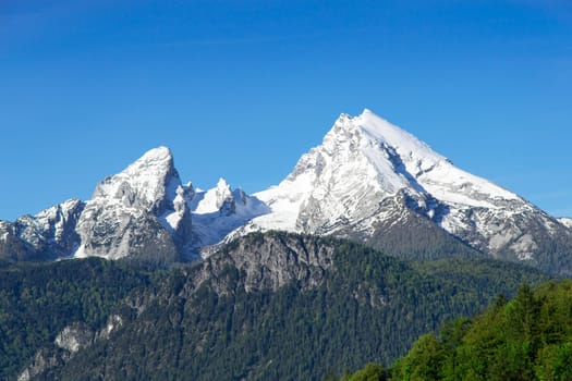 Snow-capped top mountain peaks of Watzmann Mount ridge in German Bavarian Alps. View to highland snowy landscape from high point in national park Berchtesgaden.