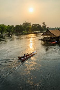 High angle view from bridge, beautiful landscape of Kwai Yai River at sunset and lifestyle of people on the waterfront in Kanchanaburi Province, Thailand