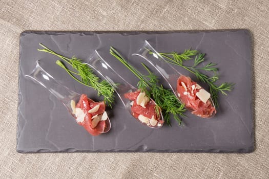Appetizer with meat, Carpaccio and parmesan served on a Spoon