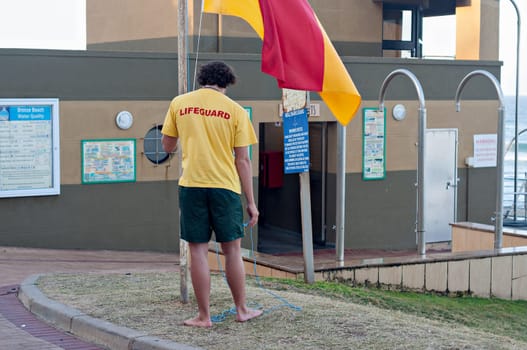 DURBAN, SOUTH AFRICA - JULY 13, 2016: Lifeguard raising the flag at the Bronze Beach surf rescue station in Umhlanga Rocks