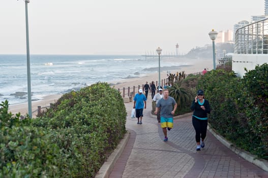 DURBAN, SOUTH AFRICA - JULY 13, 2016: Locals and tourists on the beach near the Millennium Pier and lighthouse in Umhlanga Rocks