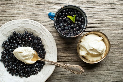 Forest blueberries with sweet cream served on plate