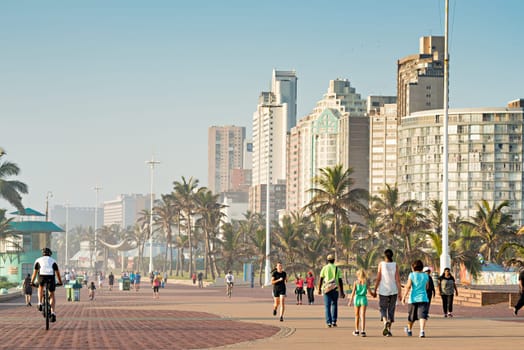 DURBAN, SOUTH AFRICA - APRIL 16, 2016: Locals and Tourists enjoying the Golden Mile Promenade just after sunrise.