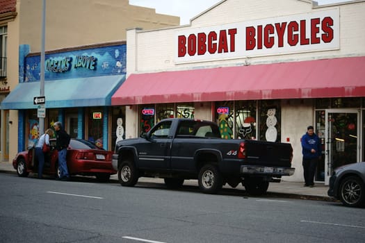 Salinas,United States - December 22,2015: Cars park in Monterey Commercial Street in front of bobcat bicycle store and oceans above pet store on December 22,2015 in Salinas.