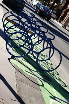 Abstract bicycle racks arranged in series cast a shadow and have the shape of a racing bike.