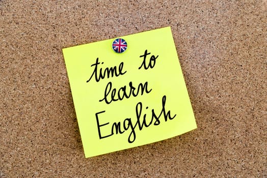 Yellow paper note pinned on cork board with Great Britain flag thumbtack, written text Time To Learn English, British Business concept