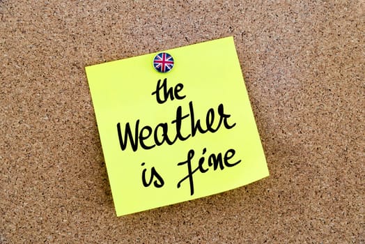 Yellow paper note pinned on cork board with Great Britain flag thumbtack, written text The Weather Is Fine, British Business concept
