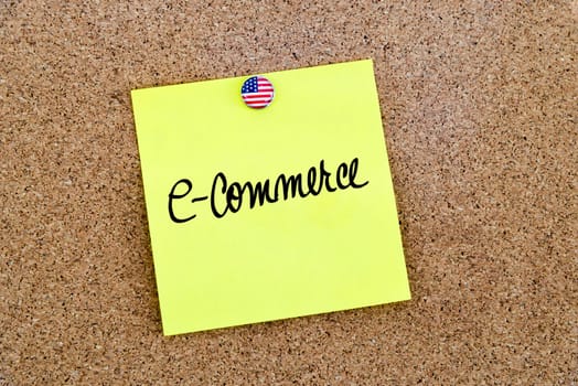 Written text E-Commerce over yellow paper note pinned on cork board