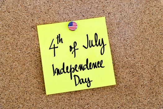Written text 4th of July Independence Day over yellow paper note pinned on cork board