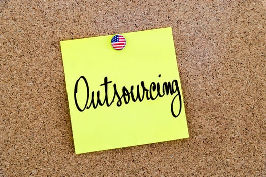 Written text Outsourcing over yellow paper note pinned on cork board