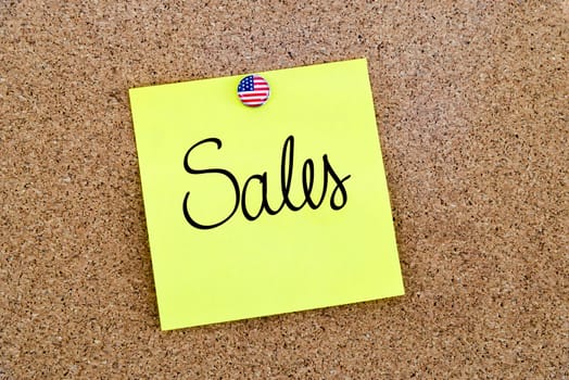 Written text Sales over yellow paper note pinned on cork board