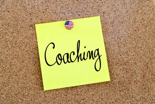 Written text Coaching over yellow paper note pinned on cork board