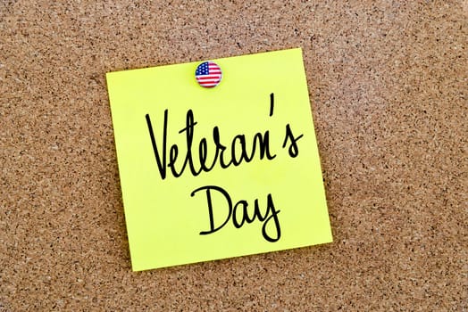 Written text Veterans Day over yellow paper note pinned on cork board