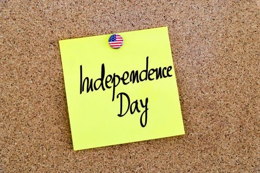 Written text Independence Day over yellow paper note pinned on cork board