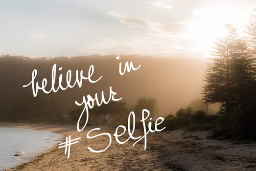 Believe In Your Selfie message. Handwritten motivational text over sunset calm sunny beach background with vintage filter applied