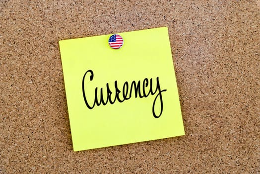 Written text Currency over yellow paper note pinned on cork board