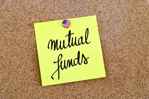 Written text Mutual Funds over yellow paper note pinned on cork board