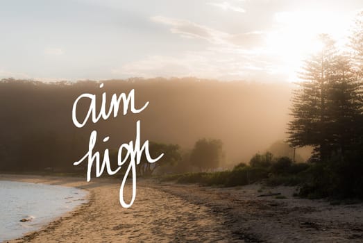 Aim High message. Handwritten motivational text over sunset calm sunny beach background with vintage filter applied