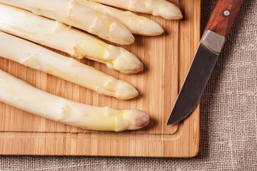 Delicate organic white asparagus ready to be peeled before they can be steamed