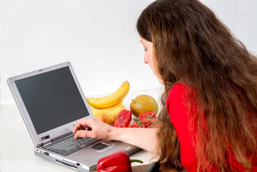dark haired woman in the kitchen using computer