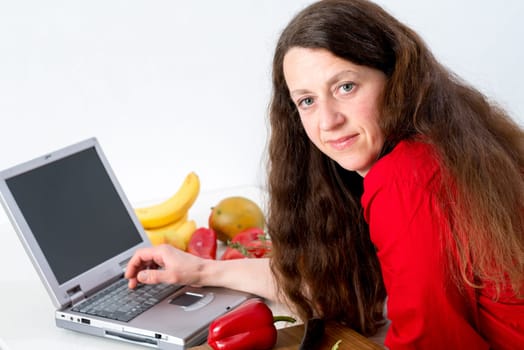 dark haired woman in the kitchen using computer