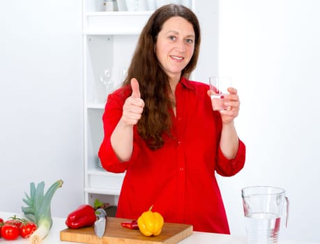 dark haired woman with thumb up in the kitchen