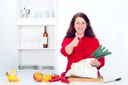dark haired woman with thumb up in the kitchen