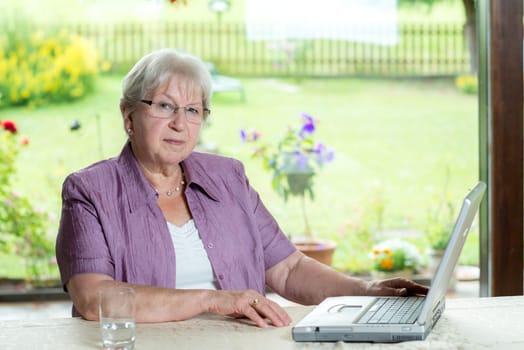 female senior is using computer at home