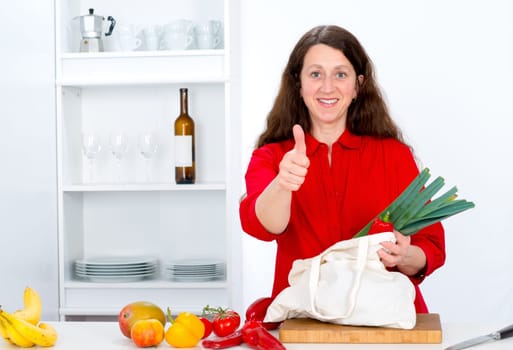 dark haired woman with thumb up in the kitchen