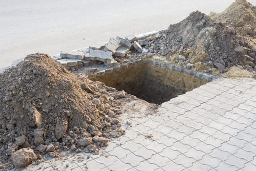 Dug a pit for planting trees on the pavement of paving slabs