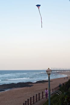 DURBAN, SOUTH AFRICA - JULY 13, 2016: An American Flag kite flies over the beach at Umhlanga Rocks, with the Millennium Pier and lighthouse in the background.