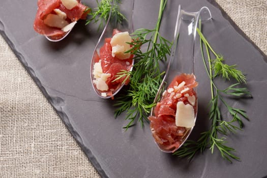 Appetizer with meat, Carpaccio and parmesan served on a Spoon