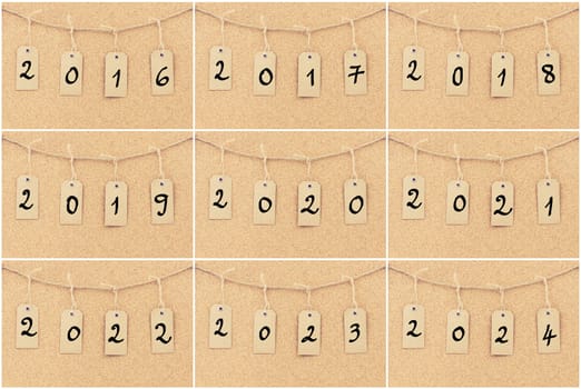 Photo collage of vintage grunge tags with years from 2016 to 2024. Numbers on rope string over cork board texture background, filter applied