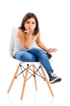 Studio portrait of a beautiful young girl sitting on a chair sending a kiss