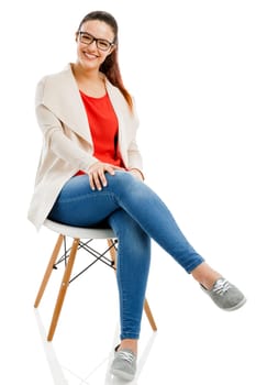 Beautiful woman sitting on a chair and smiling, isolated over white background