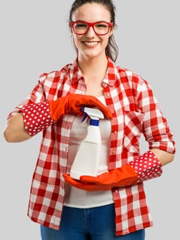 Pretty woman wearing gloves, using a cleaning spray and cleaning the house