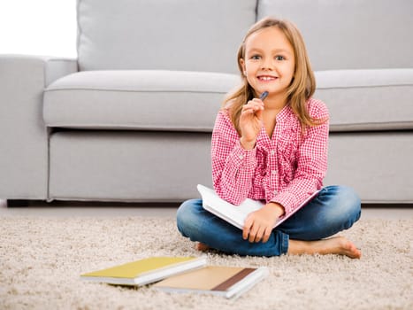 Cute little girl at home studying